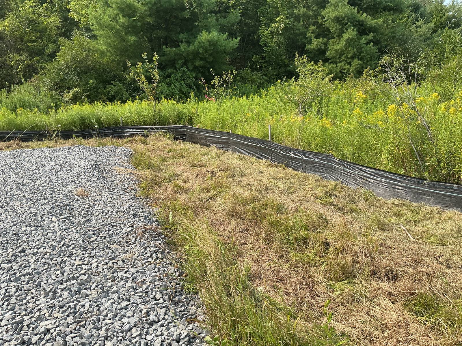 Silt fence along the edge of a gravel track