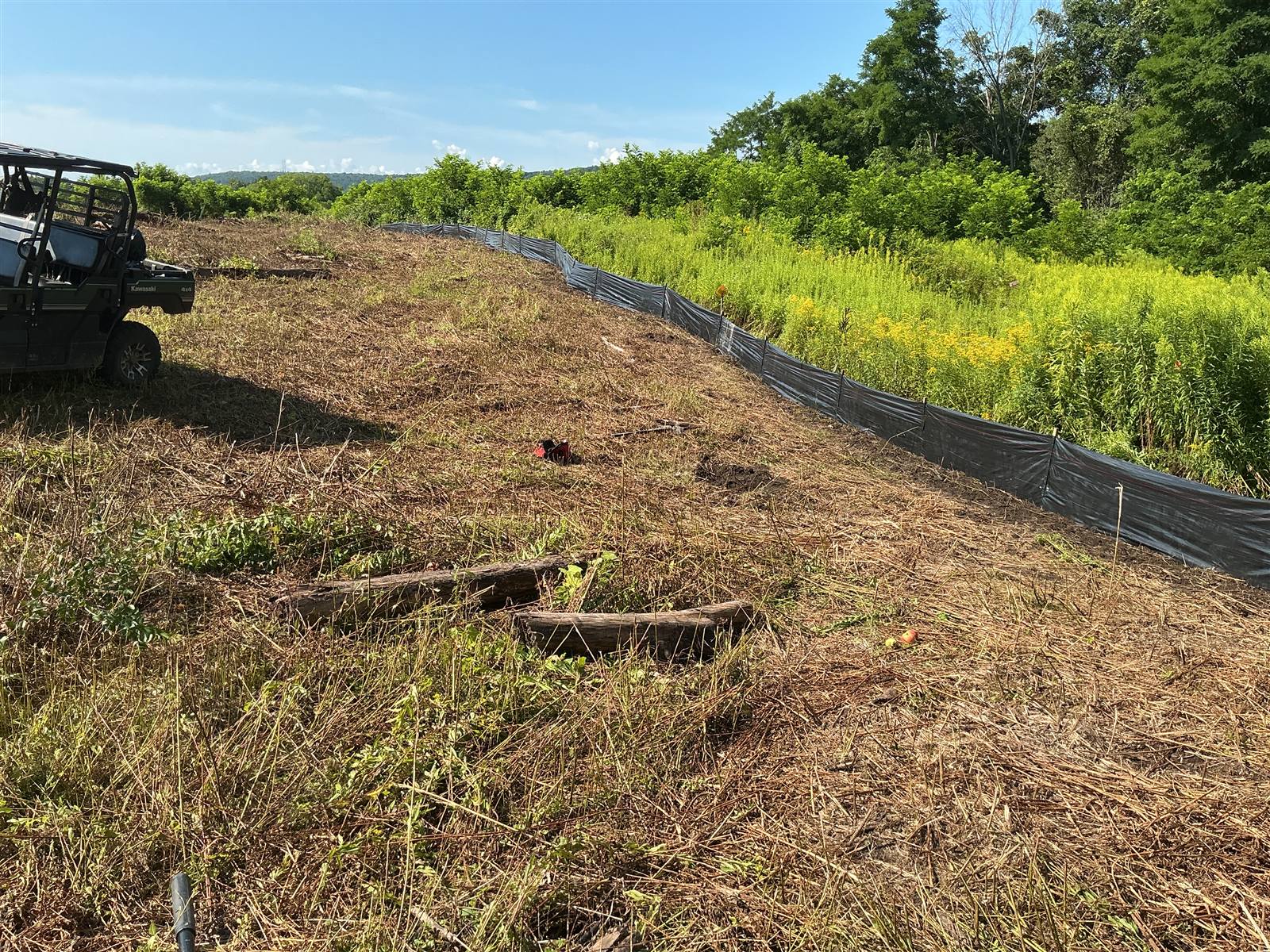 Cleared slope with silt fence installed along its toe