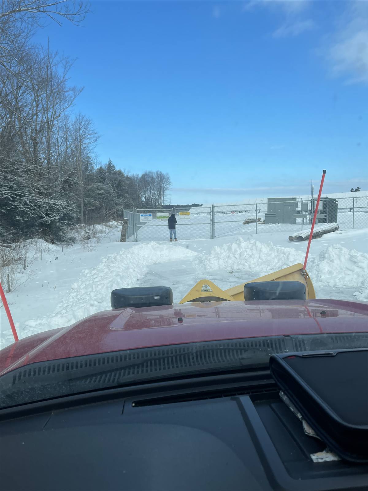 Snow plowing along a fenced solar site