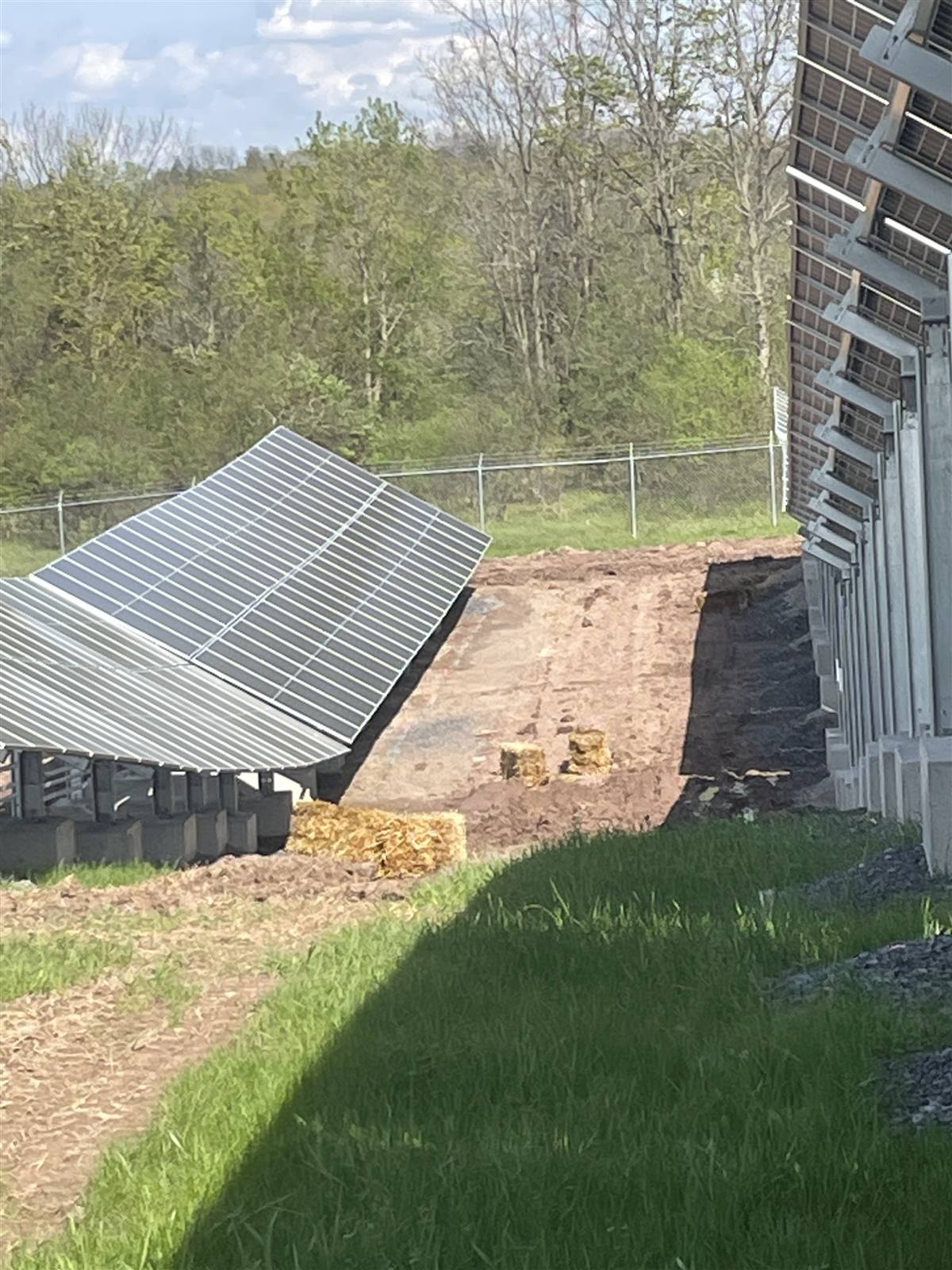 Solar tracker piers beside bare ground prepared for seeding